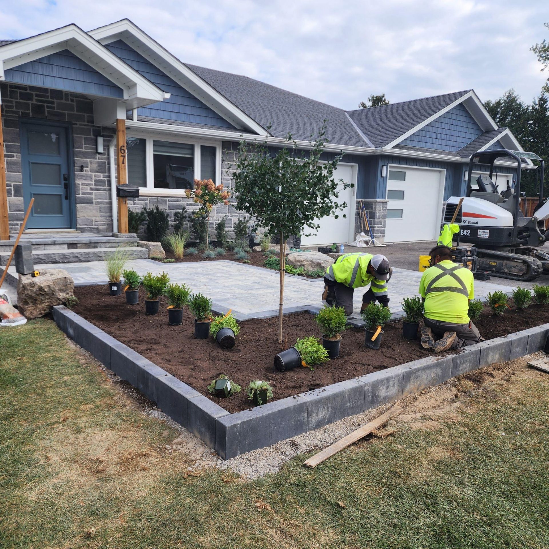 Front yard landscaping installation with paver walkway and new plantings