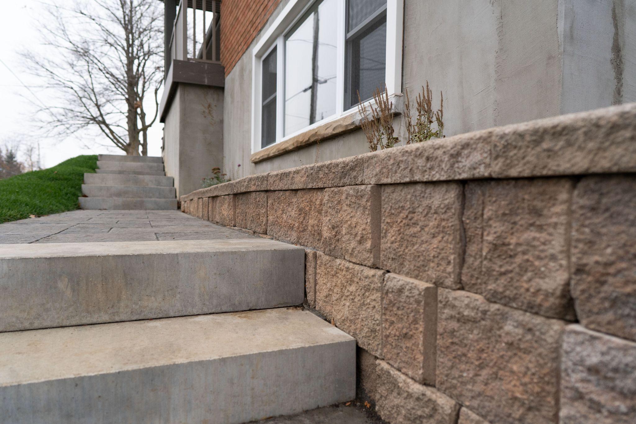 Stone retaining wall with concrete steps