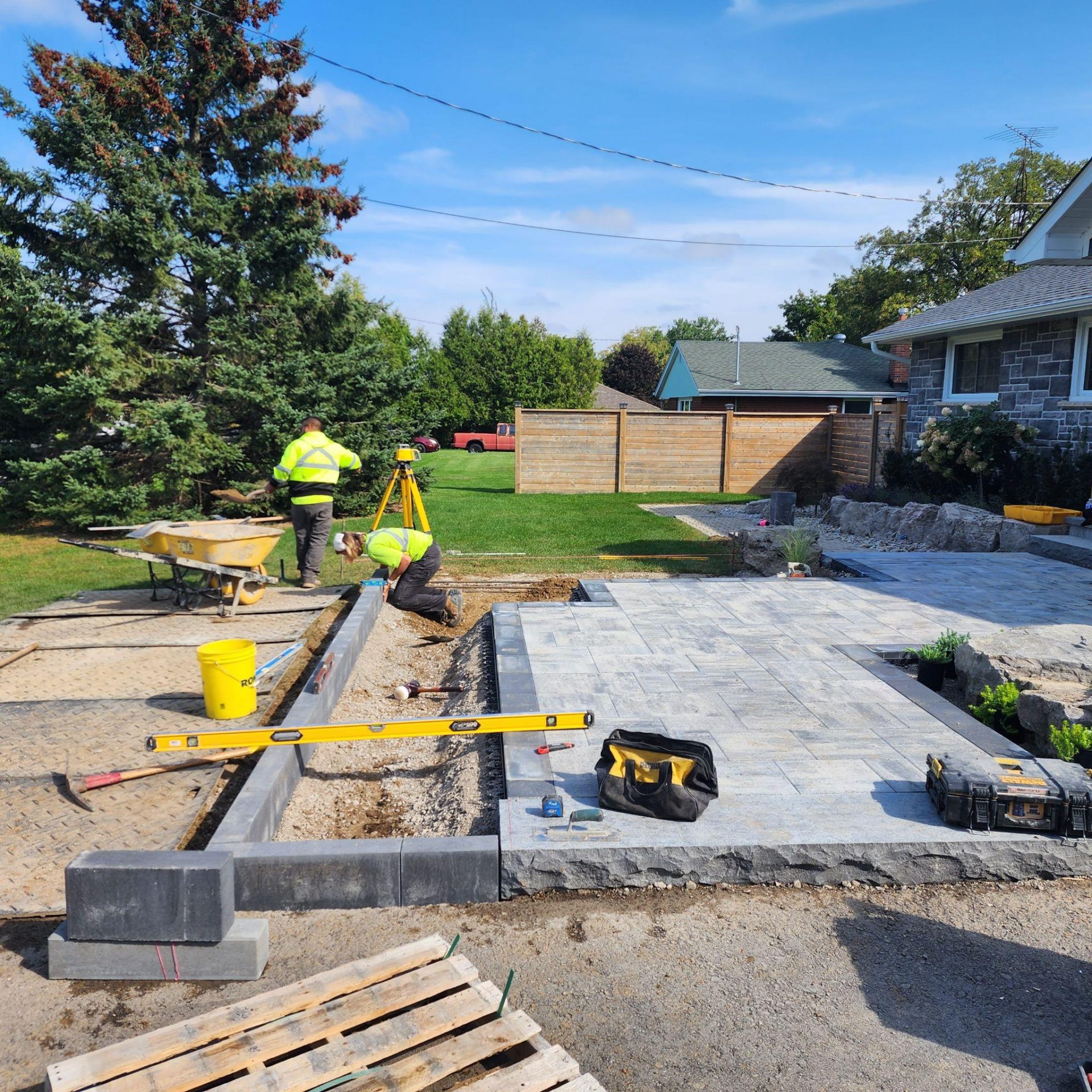Workers installing backyard stone patio